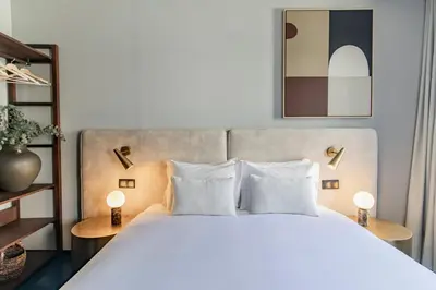 a bedroom with a large white bed with two lamps at Regras Apartments & Garden by Benefit Collection B in Porto
