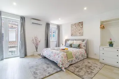 a white bedroom with a bed and a dresser at HostWise - Modern & Bright Studio in Porto
