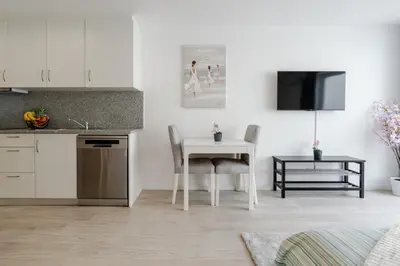 a kitchen and dining room with a table and a tv at HostWise - Modern & Bright Studio in Porto