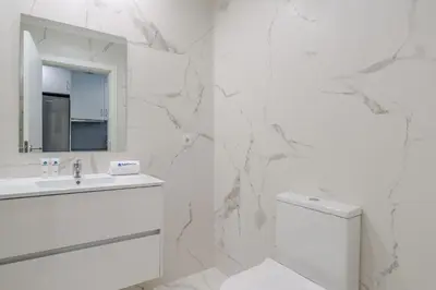 a white bathroom with a toilet and a mirror at HostWise - Modern & Bright Studio in Porto