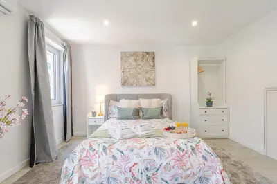 a bedroom with a large bed with a floral bedspread at HostWise - Modern & Bright Studio in Porto