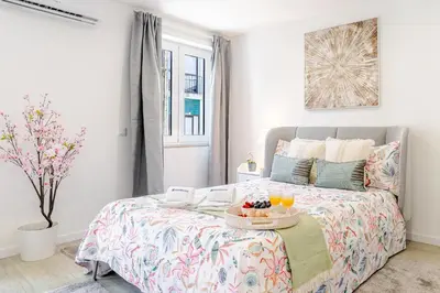 a bedroom with a bed with a tray of fruit on it at HostWise - Modern & Bright Studio in Porto