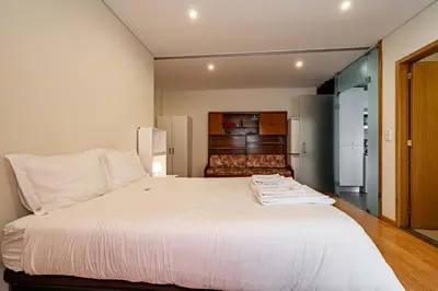 a large white bed in a room with a refrigerator at O'Porto Main Street St Catarina 2 Studio Apartment in Porto