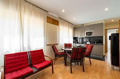 a living room with a red couch and a table and chairs at O'Porto Main Street St Catarina 2 DOWNTOWN in Porto