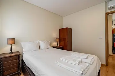 a bedroom with a white bed with towels on it at O'Porto Main Street St Catarina 2 DOWNTOWN in Porto