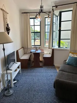 a living room with a couch and a table and windows at O Alecrim in Porto