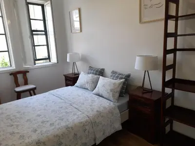 a living room with a couch and a table and windows at O Alecrim in Porto