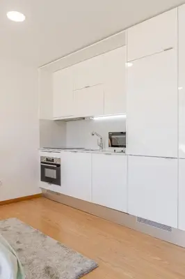 a kitchen with white cabinets and a sink at Host Wise Stylish Studio with Garage in Porto