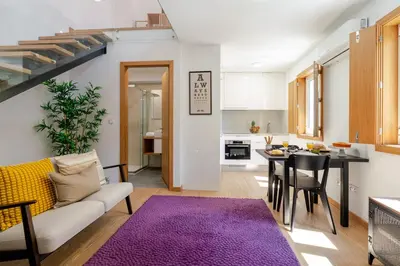 a living room with a couch and a table with a purple rug at Host Wise Stylish Studio with Garage in Porto