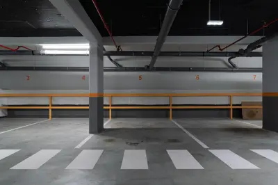 an empty parking garage with white walls and yellow poles at Host Wise Stylish Studio with Garage in Porto