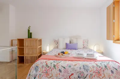 a bedroom with a bed with a tray of food on it at Host Wise Stylish Studio with Garage in Porto