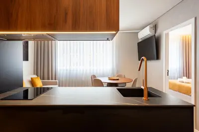 a kitchen with a sink and a living room at DoisPontoZero Fonseca Cardoso in Porto