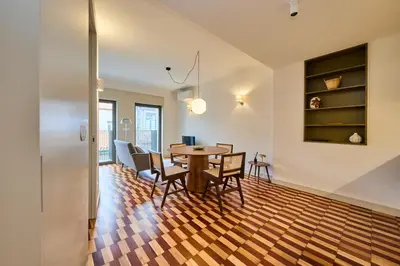 a dining room and living room with a table and chairs at VIVA Ildefonso Serviced Apartments in Porto