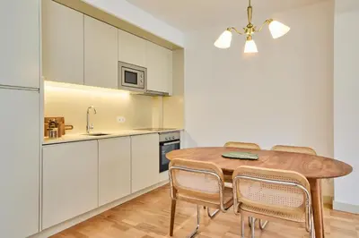 a kitchen and dining room with a wooden table and chairs at VIVA Ildefonso Serviced Apartments in Porto