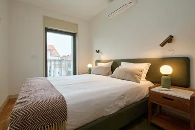 a bedroom with a large bed with a window at VIVA Ildefonso Serviced Apartments in Porto