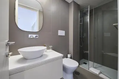 a bathroom with a sink and a toilet and a mirror at VIVA Ildefonso Serviced Apartments in Porto