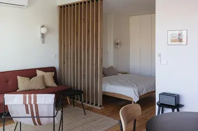 a living room with a bed and a couch and a bedroom at Oporto City View - Ferreira Cardoso in Porto
