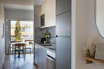 a kitchen with a refrigerator and a table at Oporto City View - Ferreira Cardoso in Porto