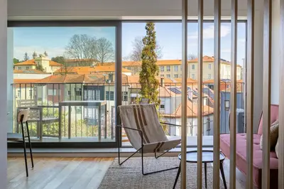 a room with a chair and a large window at Oporto City View - Ferreira Cardoso in Porto