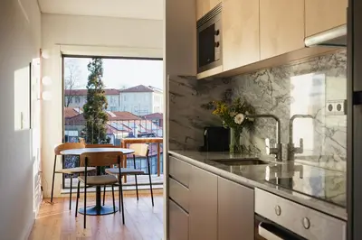 a kitchen with a table and a dining room at Oporto City View - Ferreira Cardoso in Porto