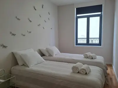 two beds with towels on them in a room at H2OPorto Miragaia - Riverfront apartments in Porto historic district in Porto