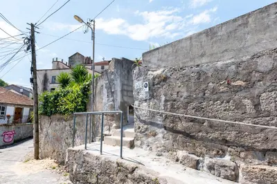 a stone wall with a staircase next to a street at Studio at Campanha Station in Porto