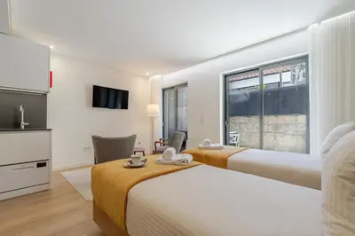 a hotel room with two beds and a tv at HostWise - Premium & Modern Building in Porto
