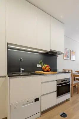 a kitchen with white cabinets and a sink at HostWise - Premium & Modern Building in Porto