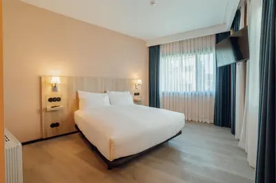 a large white bed with two pillows in a bedroom at ABC Hotel Porto - Campanhã in Porto