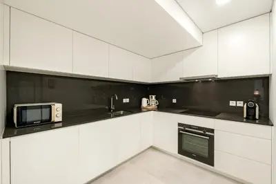 a white kitchen with white cabinets and a microwave at VIVA River Apartment Gaia in Vila Nova de Gaia
