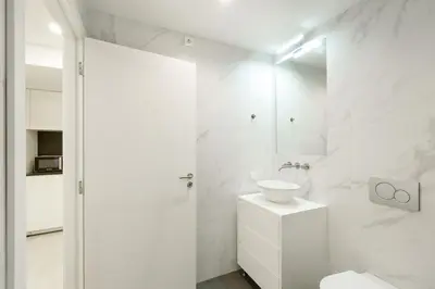 a white bathroom with a sink and a shower at VIVA River Apartment Gaia in Vila Nova de Gaia