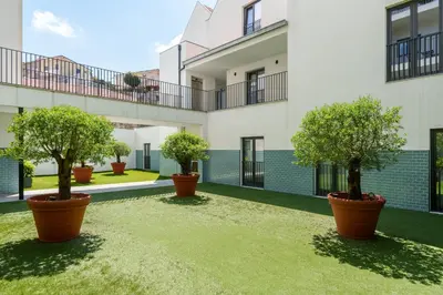 a courtyard with three potted trees inront of a building at VIVA River Apartment Gaia in Vila Nova de Gaia