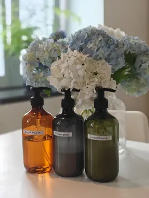 three bottles of soap and flowers on a table at Castelo River View - NEW in Vila Nova de Gaia
