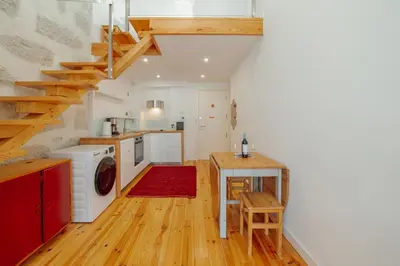 a kitchen with a washer and dryer and a staircase at Marques 1243 by Vacationy in Porto