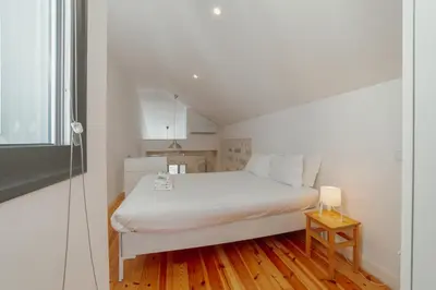 a small bedroom with a white bed and a window at Marques 1243 by Vacationy in Porto