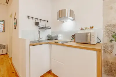 a kitchen with white cabinets and a microwave at Marques 1243 by Vacationy in Porto