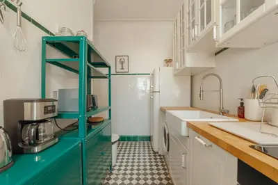a kitchen with white cabinets and a blue shelf at Downtown Retro Bolhao by Vacationy in Porto