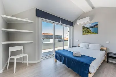 a bedroom with a bed and a chair and a large window at GuestReady - Olivieri's House in Porto