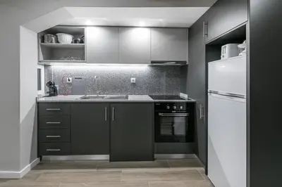 a kitchen with black cabinets and a white refrigerator at GuestReady - Olivieri's House in Porto