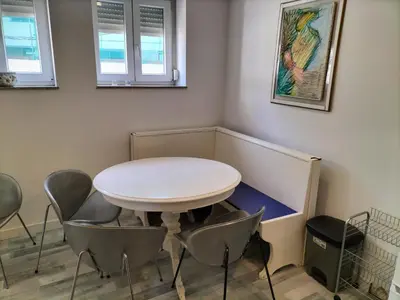 a white table and chairs in a room with windows at Casa Pedro Hispano 3B in Porto