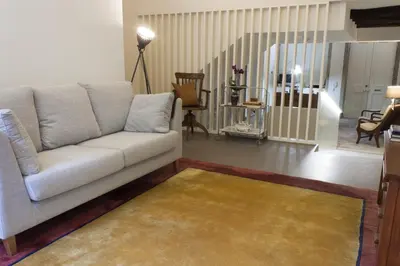 a living room with a white couch and a rug at Being Porto Hostel in Porto