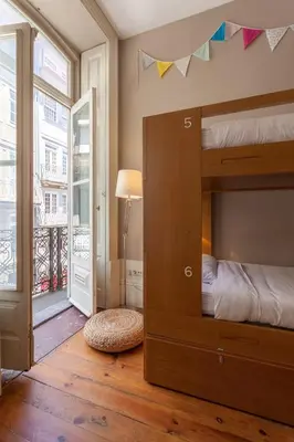 a bedroom with a bunk bed and a balcony at Being Porto Hostel in Porto