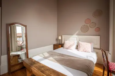 a bedroom with a bed with a table and a mirror at Being Porto Hostel in Porto
