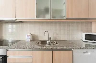 a kitchen counter with a sink and a microwave at GuestReady - Cityscape residence with balcony in Porto