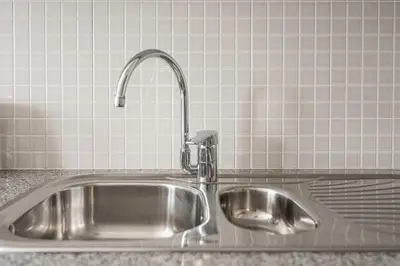 a stainless steel kitchen sink with a faucet at GuestReady - Cityscape residence with balcony in Porto