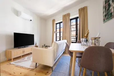 a living room with a television and a table and chairs at Art Deco 31 Luxury 2BR Apartment Downtown Metro AC in Porto