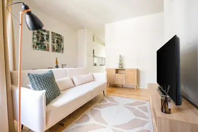 a living room with a white couch and a flat screen tv at Art Deco 31 Luxury 2BR Apartment Downtown Metro AC in Porto