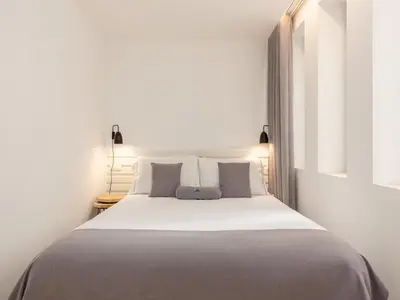 a bedroom with a large bed with white sheets and pillows at Feel Porto Bacchus Townhouse in Porto