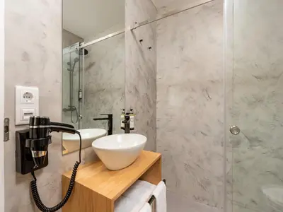 a bathroom with a sink and a glass shower at Feel Porto Bacchus Townhouse in Porto