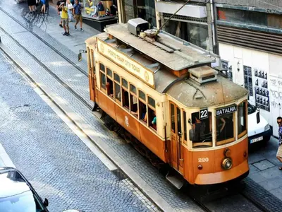 an orange trolley car on a city street at Feel Porto Bacchus Townhouse in Porto